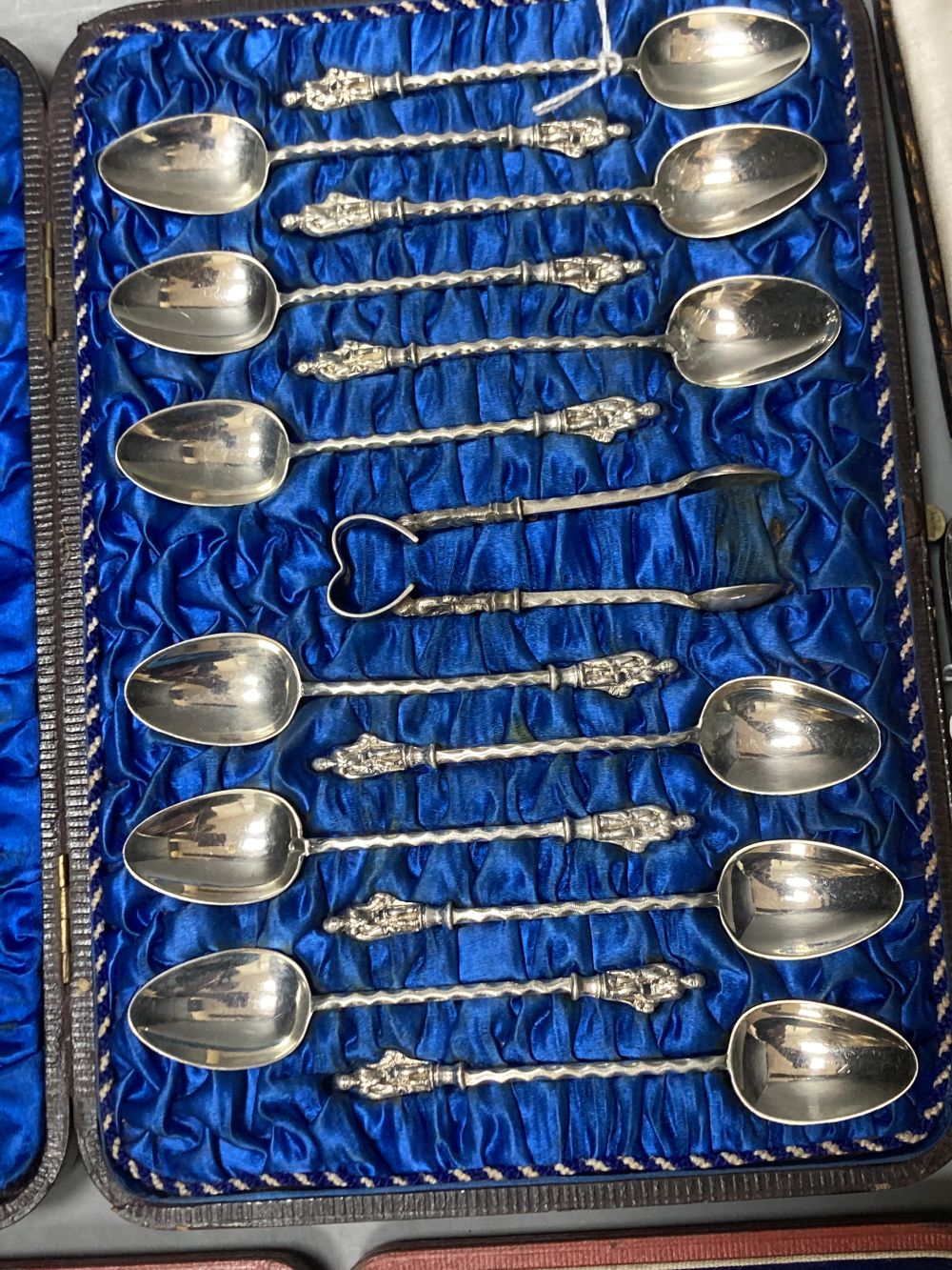 Twelve Victorian silver Apostle coffee spoons and sugar tongs, and three sets of six silver bean end coffee spoons, all cased